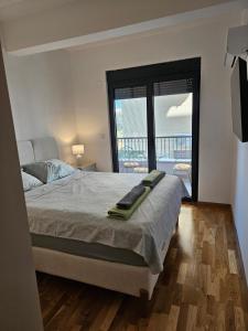 a bedroom with a large bed and a balcony at Apartman Kiki in Šušanj