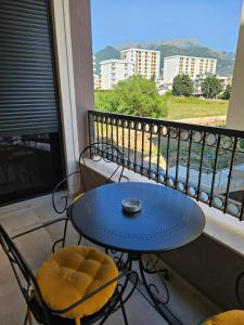 a blue table and chairs on a balcony at Apartman Kiki in Šušanj