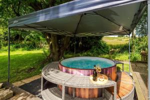 an umbrella over a hot tub under a tree at Ascot House in Buxton