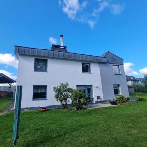 a white house with a black roof at Ferienwohnung Klippenblick in Holzhausen