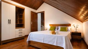 a bedroom with a large white bed with green pillows at Villa de charme in Ivato