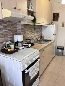 a kitchen with a white stove and a white refrigerator at Almyra Home in Kyparissia
