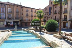 a pool of water in a street with buildings at Hotel Apartamentos Melihah in Daroca