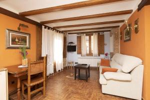 a living room with a white couch and a table at Hotel Apartamentos Melihah in Daroca