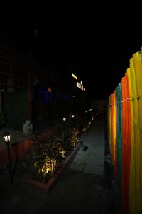 a row of lights on a fence at night at Roots in Pune
