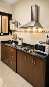 a kitchen with a stove and a microwave at Coutinho BNB in Madgaon