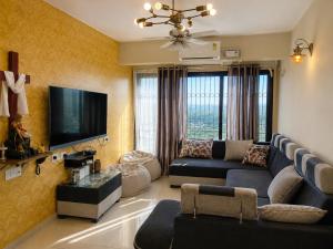 a living room with a couch and a flat screen tv at Coutinho BNB in Madgaon