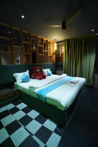 a bed with a teddy bear sitting on top of it at Roots in Pune