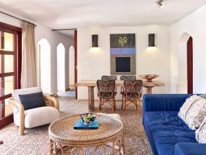 a living room with a blue couch and a table at Kasbah 3 in Cala Vadella