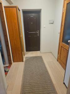 a hallway with a black door and a rug at Laeva in Pärnu