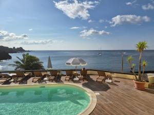 a swimming pool with a view of the ocean at Vinha da Areia Beach Hotel in Vila Franca do Campo