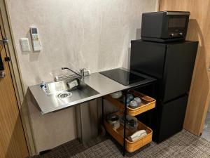 a small kitchen with a sink and a refrigerator at ホテル雅々音 in Sasebo +32 photos