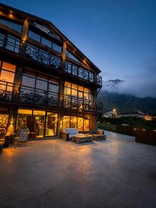 a large building with a lit up patio at night at Chemodann Kazbegi in Kazbegi
