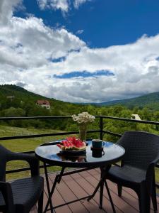 a table with a bowl of watermelon on a balcony at რაჭული სიმშვიდე Racha Serenity in Nikortsminda