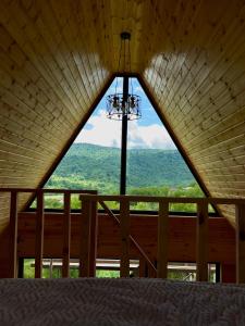 a view from the inside of a cabin with a large window at რაჭული სიმშვიდე Racha Serenity in Nikortsminda