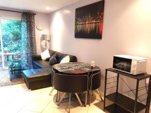a living room with a couch and a table at STUDIO Confort Clim 20min Orly-45min Paris Disney in Corbeil-Essonnes
