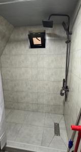 a bathroom with a shower with a tile floor and a shower at რაჭული სიმშვიდე Racha Serenity in Nikortsminda