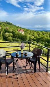 a table and chairs on a deck with a view at რაჭული სიმშვიდე Racha Serenity in Nikortsminda