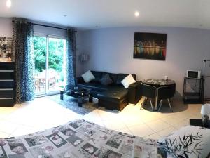 a living room with a couch and a table at STUDIO Confort Clim 20min Orly-45min Paris Disney in Corbeil-Essonnes