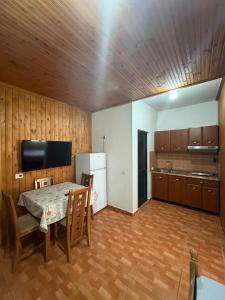 a kitchen with a table and chairs and a refrigerator at Sun & Sea Shengjin in Lezhë