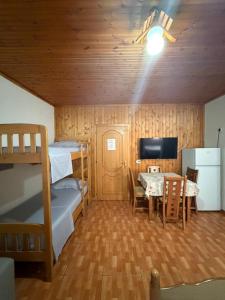 a room with bunk beds and a table and a television at Sun & Sea Shengjin in Lezhë