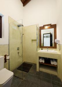 a bathroom with a sink and a shower with a mirror at Sri Yoga Shala in Unawatuna