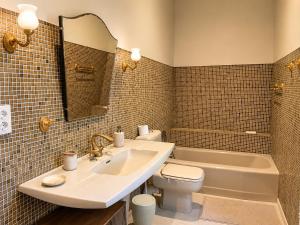 a bathroom with a sink and a toilet and a tub at La Selva in Busserolles