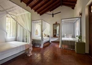 a bedroom with two beds and a mirror at Sri Yoga Shala in Unawatuna