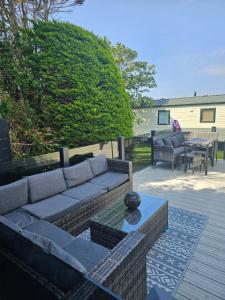 a couch sitting on a patio with a table at Relax - recharge - reignite in Llanwnda