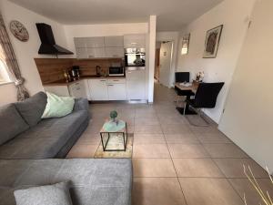 a living room with a couch and a table and a kitchen at Am Dollespark in Bodenheim