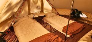 a room with two beds in a tent at Nid et Toiles in Bernadets-Debat