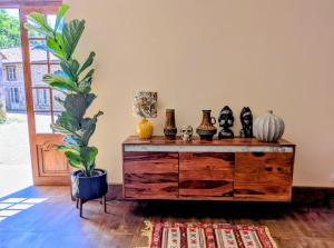 a room with a wooden dresser with vases and a plant at La Selva in Busserolles
