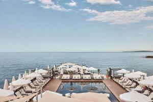 a pool with chairs and umbrellas on the water at Puro Grand Hotel in Palma de Mallorca