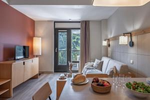 a living room with a table with a bowl of fruit at Résidence Pierre & Vacances La Forêt in Flaine