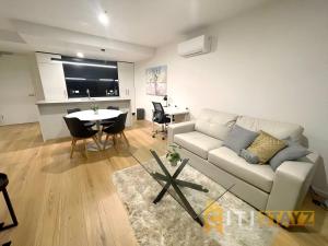 a living room with a white couch and a table at Delicious in Dickson - 1bd 1bth in Canberra