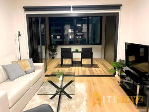 a living room with a white couch and a table at Delicious in Dickson - 1bd 1bth in Canberra +9 photos