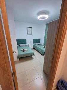 a room with two green beds and a door at Moncofa Beaches Apartment in Moncófar