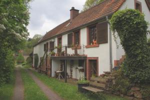 a white house with a bench in front of it at Ferienhaus Zum Herbertsche in Lemberg