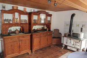 a kitchen with wooden cabinets and a microwave at Ferienhaus Zum Herbertsche in Lemberg +6 photos