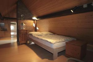 a bedroom with a bed and a wooden wall at Ferienhaus Zum Herbertsche in Lemberg