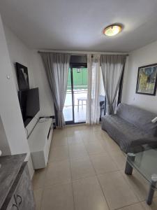 a living room with a couch and a tv at Moncofa Beaches Apartment in Moncófar