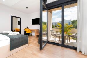 a bedroom with a bed and a balcony with a table at Asterias Residence - New Opening 2026 in Rovinj +110 photos