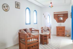 a living room with wooden furniture and windows at Dar Beate Sousse Medina in Sousse +34 photos