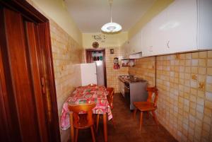 a small kitchen with a table and a refrigerator at I due cipressi in Cagli