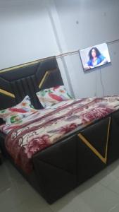 a bed in a room with a picture on the wall at Sky Blue Guest House Buea in Buea