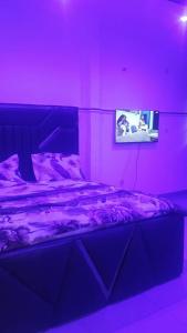 a bedroom with a bed in a purple room at Sky Blue Guest House Buea in Buea