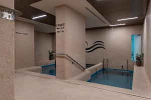 a swimming pool in a building with blue water at Azamra in Uman