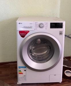 a white washing machine with its door open at Felt painting in Kara-Suu