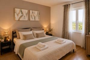 a bedroom with a large bed with two towels on it at Villa Vale in Labin