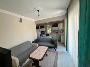 a living room with a couch and a table at Garden Prizma Apart in Kemer